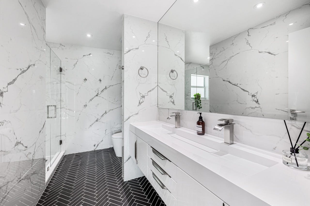 Modern bathroom with marble tile walls and herringbone floor